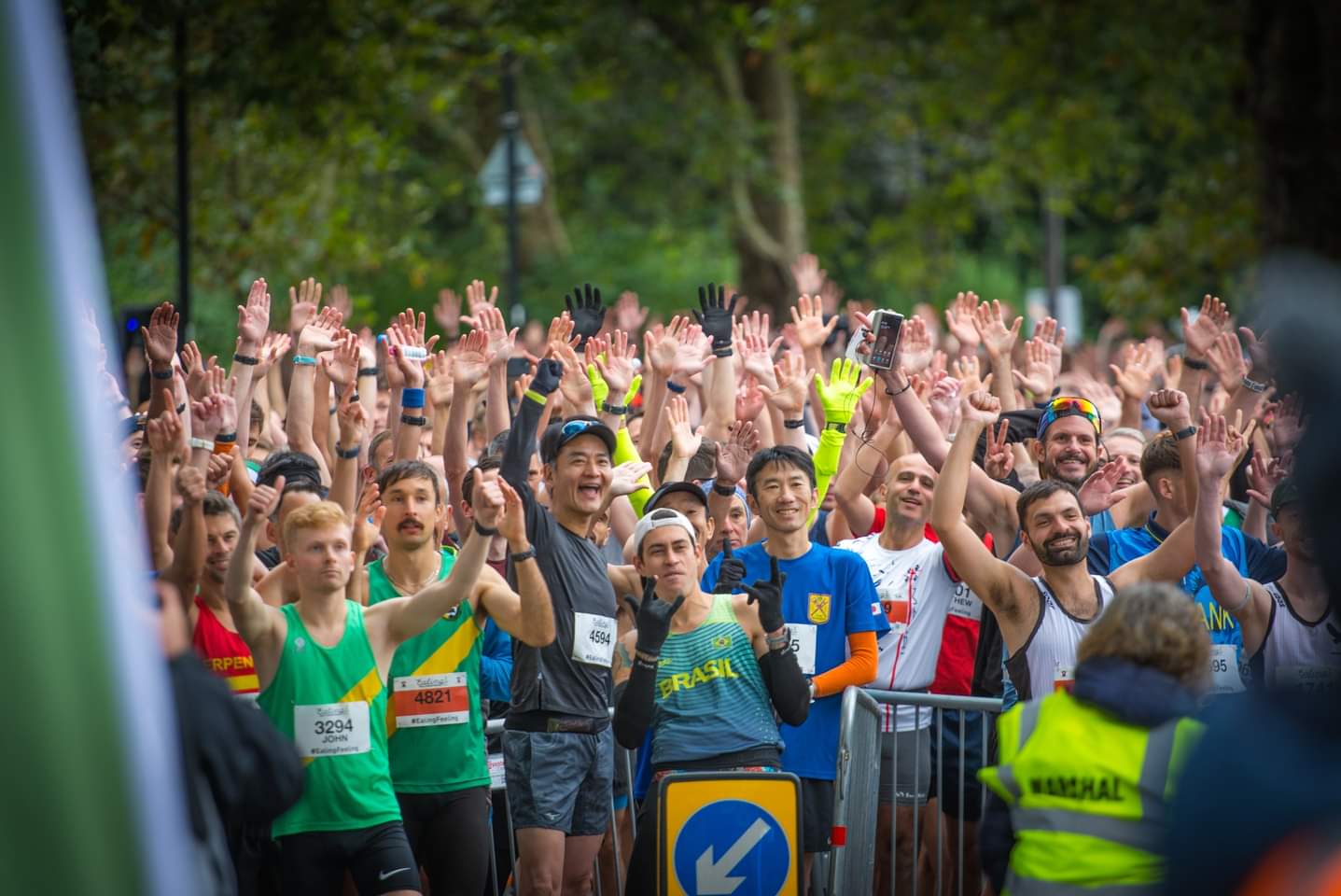 Runners with hands raised at the start line